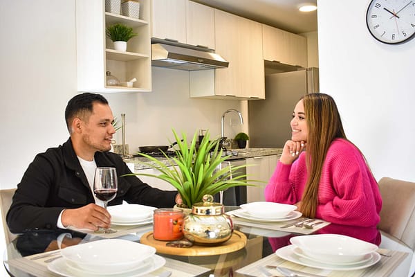 Un hombre y una mujer sentados en la mesa de una cocina.