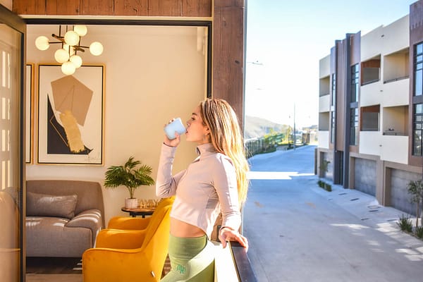 Una mujer disfrutando de una taza de café en el balcón de un departamento de Privada Cobalto.
